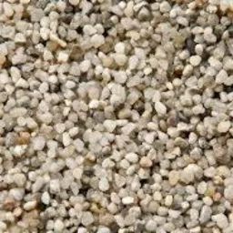 Drobny piasek kwarcowy o granulacji 2,0-4,0 mm, mieszanka jasnych i beżowych ziaren, widoczne nieregularne kształty i tekstura.