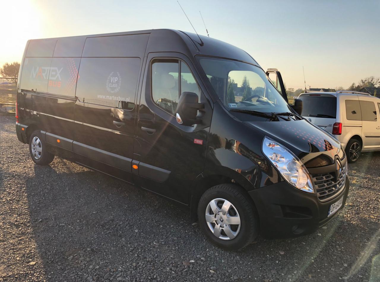 Czarny bus marki Renault Master z otwartymi drzwiami po stronie kierowcy, zaparkowany na żwirowym podłożu, z logo firmy Martex Bus i napisem VIP Class na boku.