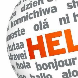 Kula ziemska z napisem 'HELLO' w kolorze pomarańczowym i powitaniami w różnych językach w kolorze szarym, częściowo widoczna, na białym tle.