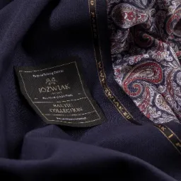 Granatowa tkanina wełniana z wszywką 'JÓŹWIAK Poznań Baltic Collection' i ozdobną podszewką w paisley