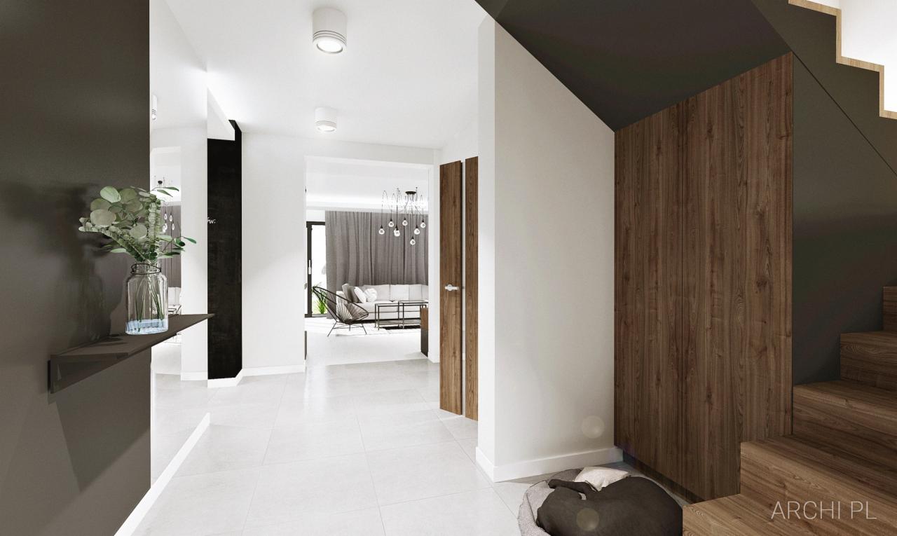 Nowoczesny przedpokój z białymi płytkami podłogowymi, ciemnoszarą ścianą z półką i wazonem z zielonymi gałązkami, drewnianymi drzwiami i schodami oraz widokiem na salon z szarą sofą i designerskim...