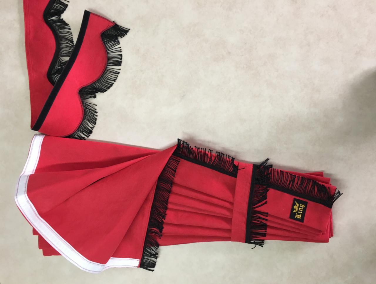 Czerwone, dekoracyjne zasłonki samochodowe z czarnymi frędzlami i logo 'King' na metce, leżące na jasnym tle.