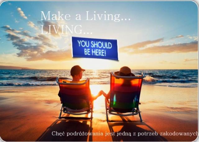 Para siedzi na plaży w krzesłach, trzymając się za ręce podczas zachodu słońca nad morzem, z hasłem 'YOU SHOULD BE HERE!' na banerze.