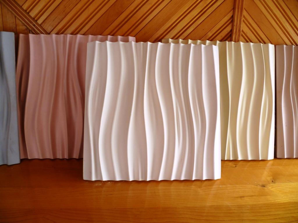 Faliste panele ścienne 3D w pastelowych odcieniach, ustawione na drewnianym tle. Dekoracyjne wykończenie wnętrz, nowoczesny design.