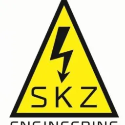 Żółty trójkątny znak ostrzegawczy z czarną strzałką symbolizującą wyładowanie elektryczne, napisem 'SKZ' i 'ENGINEERING' na białym tle.