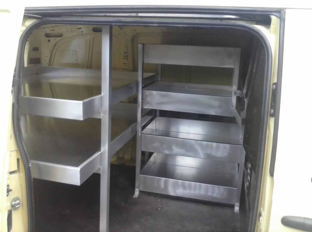 Wnętrze furgonetki z metalowymi regałami na narzędzia, wykonane w Tuliszkowie. Widoczne półki i solidna konstrukcja, zapewniające porządek i łatwy dostęp do sprzętu.