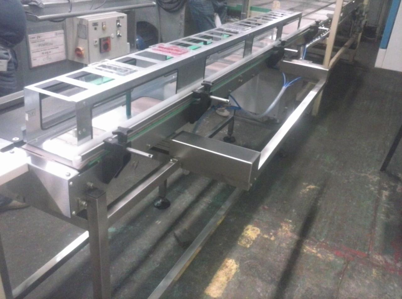 Metalowa konstrukcja taśmociągu przemysłowego z blachy nierdzewnej, widok z boku, z elementami automatyki i instalacji pneumatycznej.