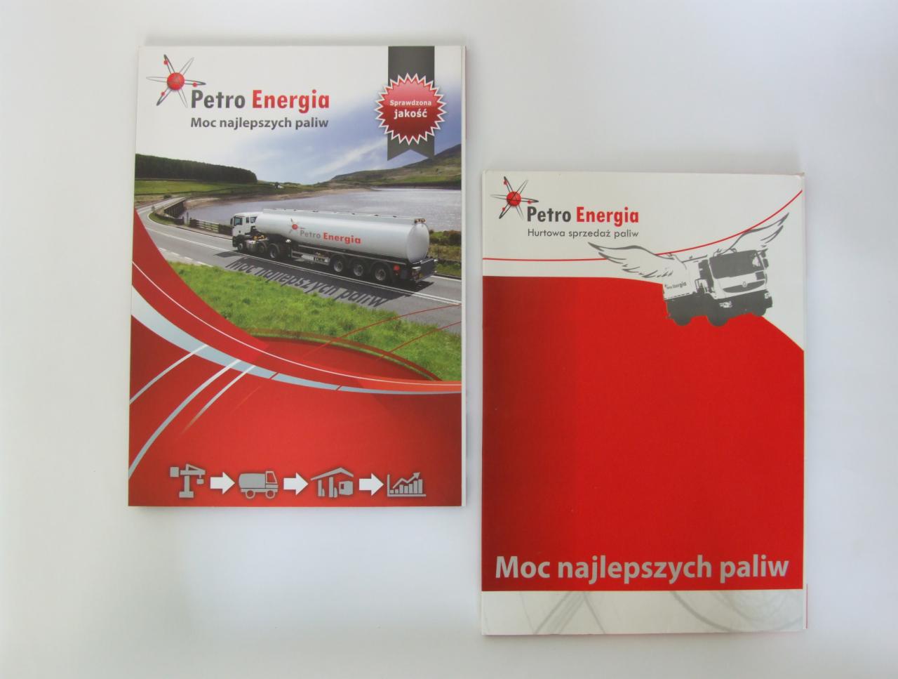 Dwa katalogi firmowe Petro Energia z Łodzi. Jeden z cysterną na tle krajobrazu, drugi z grafiką ciężarówki ze skrzydłami, oba z hasłem 'Moc najlepszych paliw'.