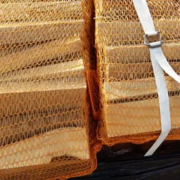 Pakiety drewnianych blatów w siatce, zabezpieczone białą taśmą transportową, gotowe do montażu w kuchni lub łazience. Widok z góry na czarnym podłożu.