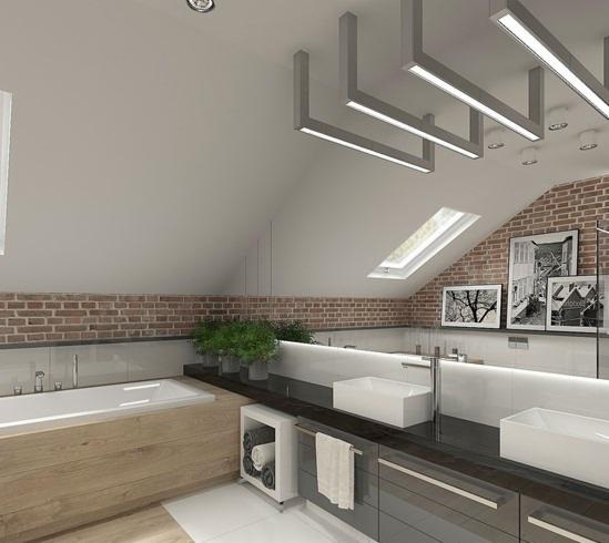 Stylowa łazienka na poddaszu z ceglaną ścianą, nowoczesnym oświetleniem i białymi umywalkami. Widoczne okno dachowe i rośliny doniczkowe.
