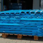 Paleta z niebieskimi, foliowymi workami ułożonymi warstwami, widoczne zgrzewy, magazynowe tło w lekkim rozmyciu.