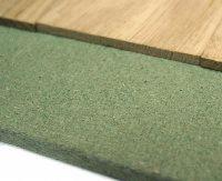 Obrzeże z jasnego drewna na zielonej, teksturowanej powierzchni z widoczną strukturą włókien. Ujęcie z bliska, ukazujące detale materiałów.