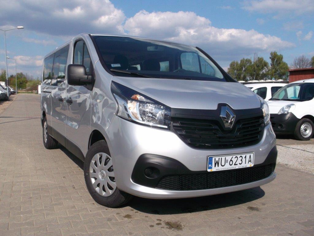 Srebrny bus Renault Trafic z polską tablicą rejestracyjną WU-6231A, zaparkowany na brukowanym placu w słoneczny dzień.