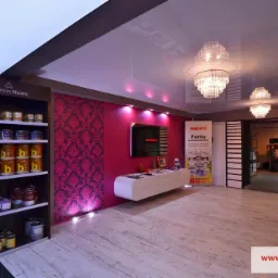 Salon z ekspozycją farb Benjamin Moore i Imperat, wzorzysta tapeta, podświetlony sufit napinany z kryształowymi żyrandolami. Jasna podłoga imitująca drewno.