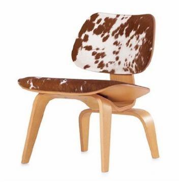 Krzesło z drewnianą ramą i obiciem z naturalnej skóry krowiej w brązowo-białe łaty.