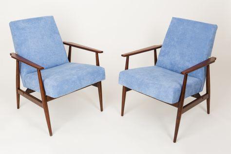 Dwa identyczne fotele z drewnianą ramą i jasnoniebieską tapicerką na białym tle.