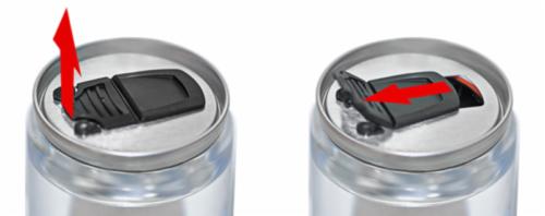 Dwa ujęcia puszki z napojem, pokazujące mechanizm otwierania z czarną klapką; strzałki wskazują kierunek ruchu klapki w procesie otwierania.