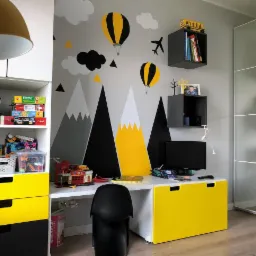 Pokój dziecięcy z biurkiem, regałem i ścianą z motywem gór, balonów i samolotu, utrzymany w kolorystyce szaro-żółto-czarnej.