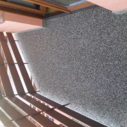 Balkon z wykończoną, szarą, kamyczkową posadzką żywiczną i brązową balustradą, widok z góry.