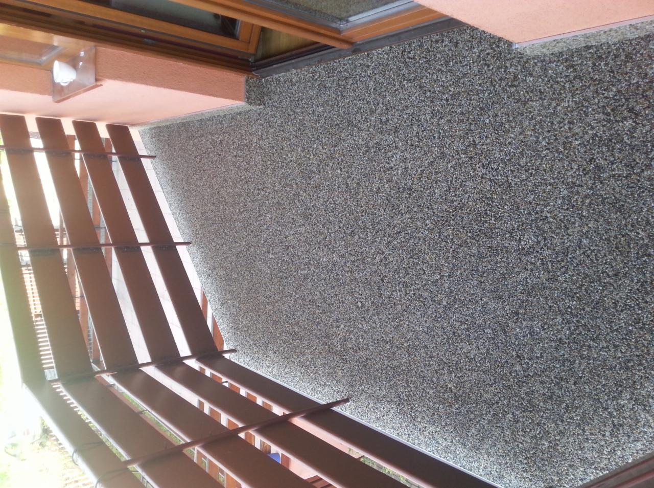 Balkon z wykończoną, szarą, kamyczkową posadzką żywiczną i brązową balustradą, widok z góry.