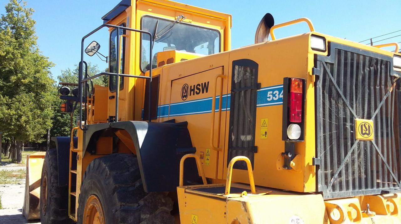 Żółta ładowarka HSW 534 E z widocznym logo producenta i tabliczką informacyjną, zaparkowana na zewnątrz w słoneczny dzień.