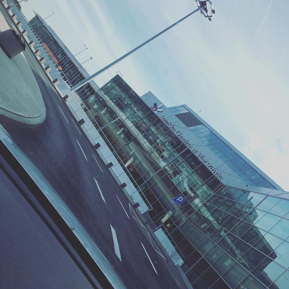 Lotnisko Chopina w Warszawie z widoczną drogą dojazdową i charakterystycznym oświetleniem.