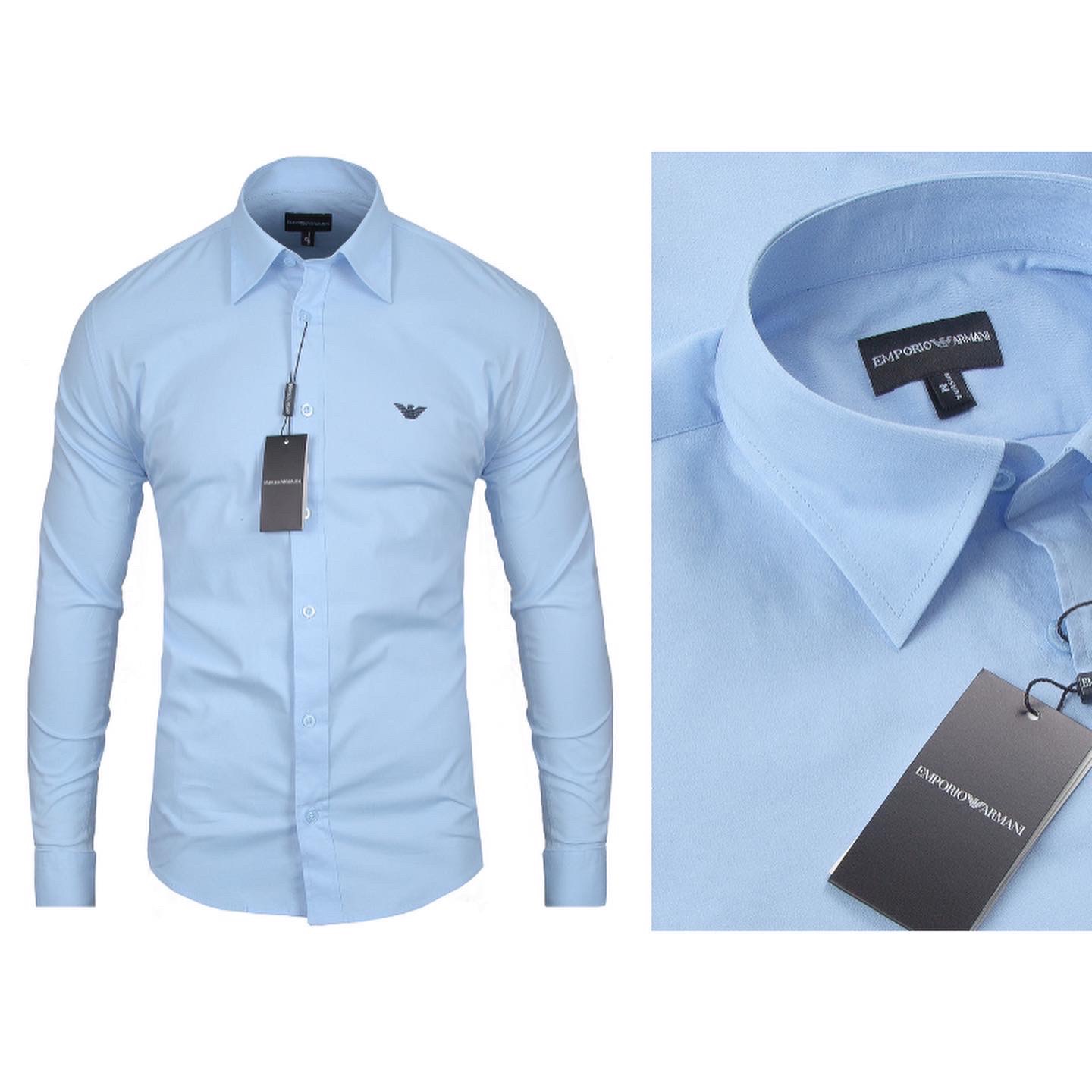 Błękitna koszula męska Emporio Armani z długim rękawem, zapinana na guziki, z metką i logo marki, na jasnym tle.