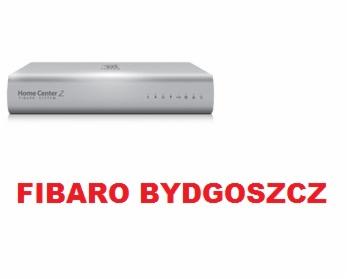 Centrala alarmowa Fibaro Home Center 2 na białym tle, z widocznymi diodami stanu i napisem 'Fibaro Bydgoszcz' w czerwonej czcionce poniżej.