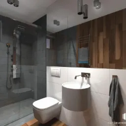 Nowoczesna łazienka z kabiną prysznicową typu walk-in, wiszącą umywalką i toaletą. Ściany wykończone płytkami imitującymi kamień w odcieniach szarości oraz drewnianymi panelami. Widoczne...