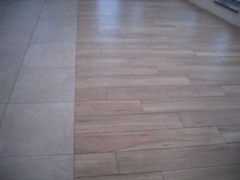 Połączenie płytek ceramicznych w odcieniach beżu z panelami podłogowymi imitującymi drewno, widoczne na podłodze w łazience.