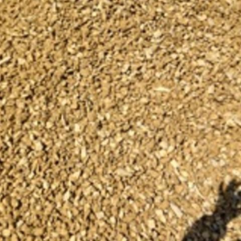 Kruszywo dolomitowe w jasnym odcieniu beżu, drobne frakcje, widoczny cień osoby robiącej zdjęcie w prawym dolnym rogu.