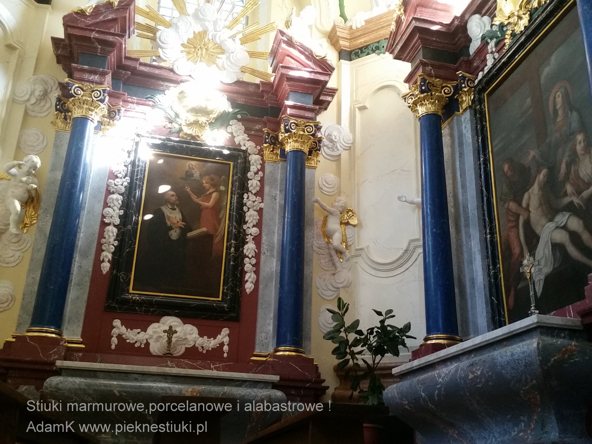 Dekoracyjne wykończenie ściany z marmurowymi kolumnami, stiukami i obrazami w stylu sakralnym, oświetlone promieniami światła z góry.