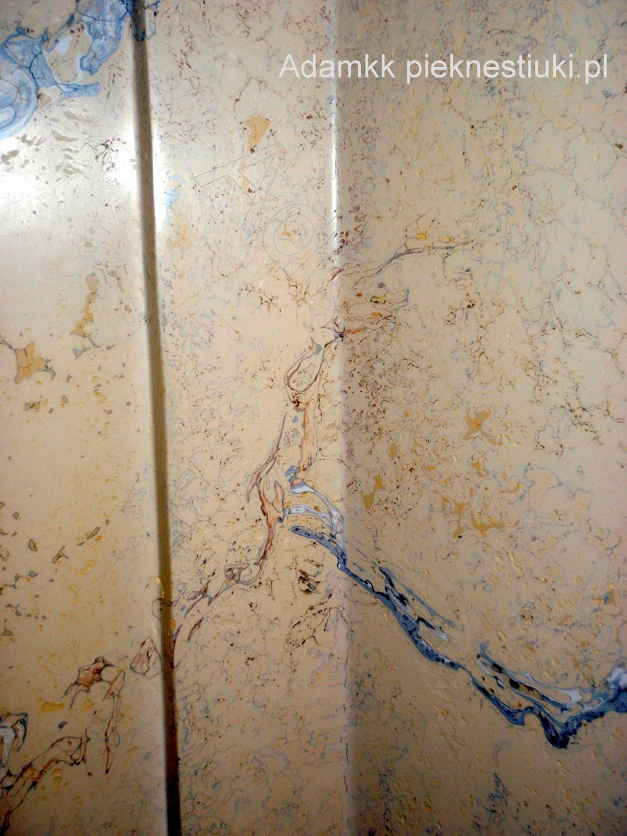 Ściana pokryta alabastrowym stiukiem marmurowym z wyraźnymi żyłkami w odcieniach beżu, błękitu i brązu, tworzącymi unikalny wzór na styku dwóch ścian.