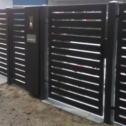 Nowoczesne, poziome, metalowe ogrodzenie w kolorze antracytowym z furtką wyposażoną w skrzynkę na listy i domofon, widoczne z zewnątrz posesji.