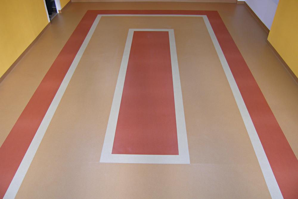 Wzorzysta, wielokolorowa wykładzina PCV z bordiurą w Bojano. Nowoczesny design podłogi z geometrycznym wzorem i kontrastującymi kolorami. Wykładzina w korytarzu.