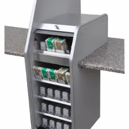 Metalowy regał ekspozycyjny na papierosy, z wysuwanymi półkami i szarą, nakrapianą powierzchnią blatu po bokach. Widok z przodu, oświetlenie studyjne.