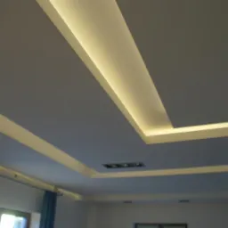 Sufit podwieszany z oświetleniem LED w geometrycznym wzorze, widok z dołu. Białe ściany i niebieskie zasłony w tle. Nowoczesny design wnętrza.