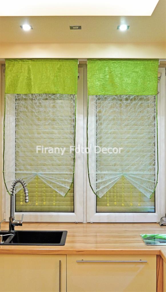 Nowoczesne, zielone zasłony rzymskie z delikatnym wzorem, wiszące w oknie nad blatem kuchennym z widocznym kranem i zlewozmywakiem. Minimalistyczny styl.