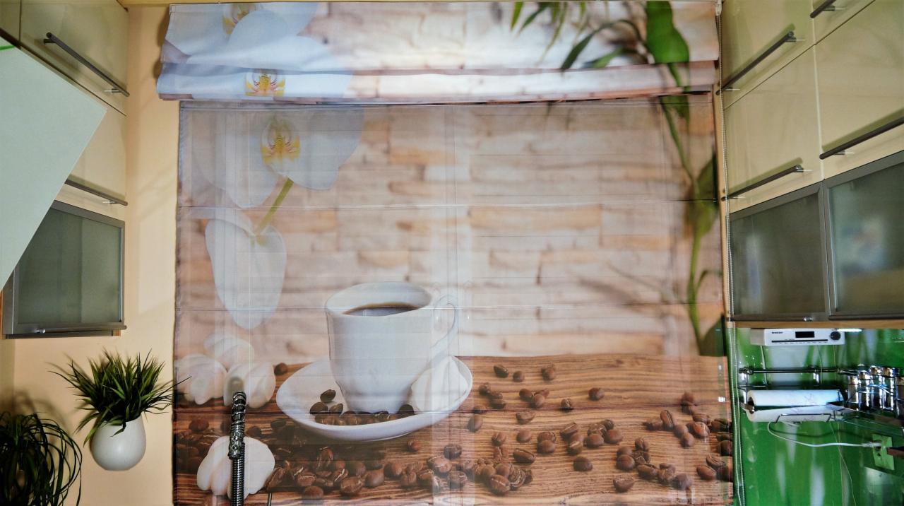 Zasłona rzymska z nadrukiem motywu kawowego w kuchni. Widoczne szafki kuchenne i roślina doniczkowa. Dekoracja okna z unikalnym wzorem.