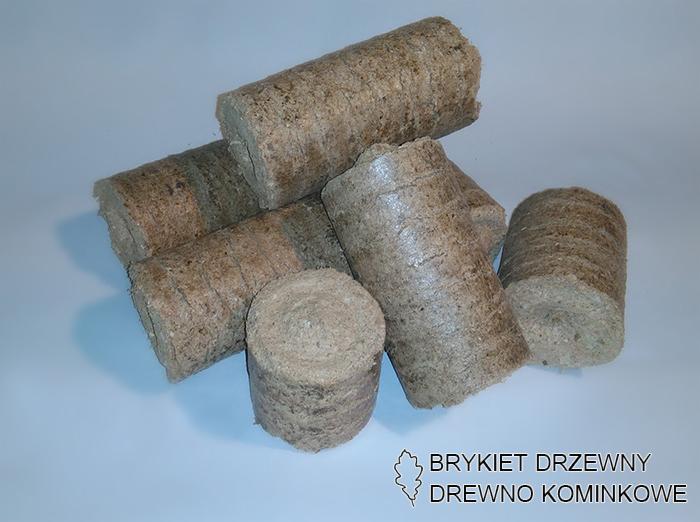 Ułożone blisko siebie cylindryczne pale z sprasowanych trocin na jednolitym tle, z widocznym logo firmy w prawym dolnym rogu.