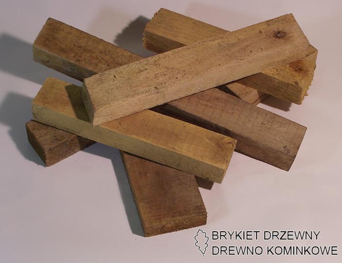 Stos pociętych, prostokątnych kawałków drewna opałowego w ciepłych odcieniach brązu, ułożonych na jasnym tle. Widoczne słoje i naturalna faktura drewna.