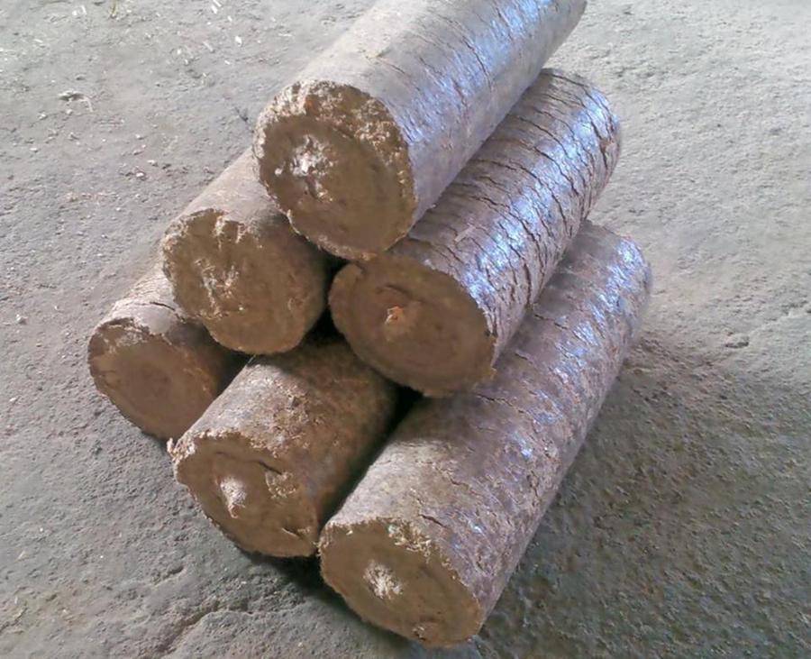 Ułożone brykiety drzewne RUF z widoczną strukturą włókien, gotowe do transportu od producenta z Zaręb Kościelnych. Szary, betonowy plac.