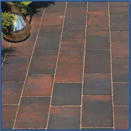 Ułożona nawierzchnia z prostokątnych elementów w odcieniach brązu i grafitu, z dekoracyjnym dzbankiem w lewym górnym rogu. Widok z góry, ukośny kadr.