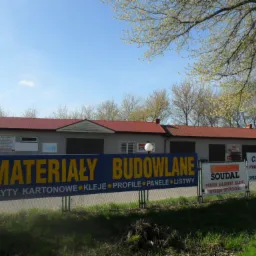 Skład budowlany z szyldem 'Materiały Budowlane'. W ofercie płyty kartonowe, kleje, profile, panele, listwy, pianki, silikony, wyroby dekarskie i panele podłogowe.