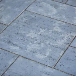 Niebiesko-szara kostka brukowa ułożona na nawierzchni w Tarnowie, widok z bliska, delikatna faktura z ciemnymi plamkami.