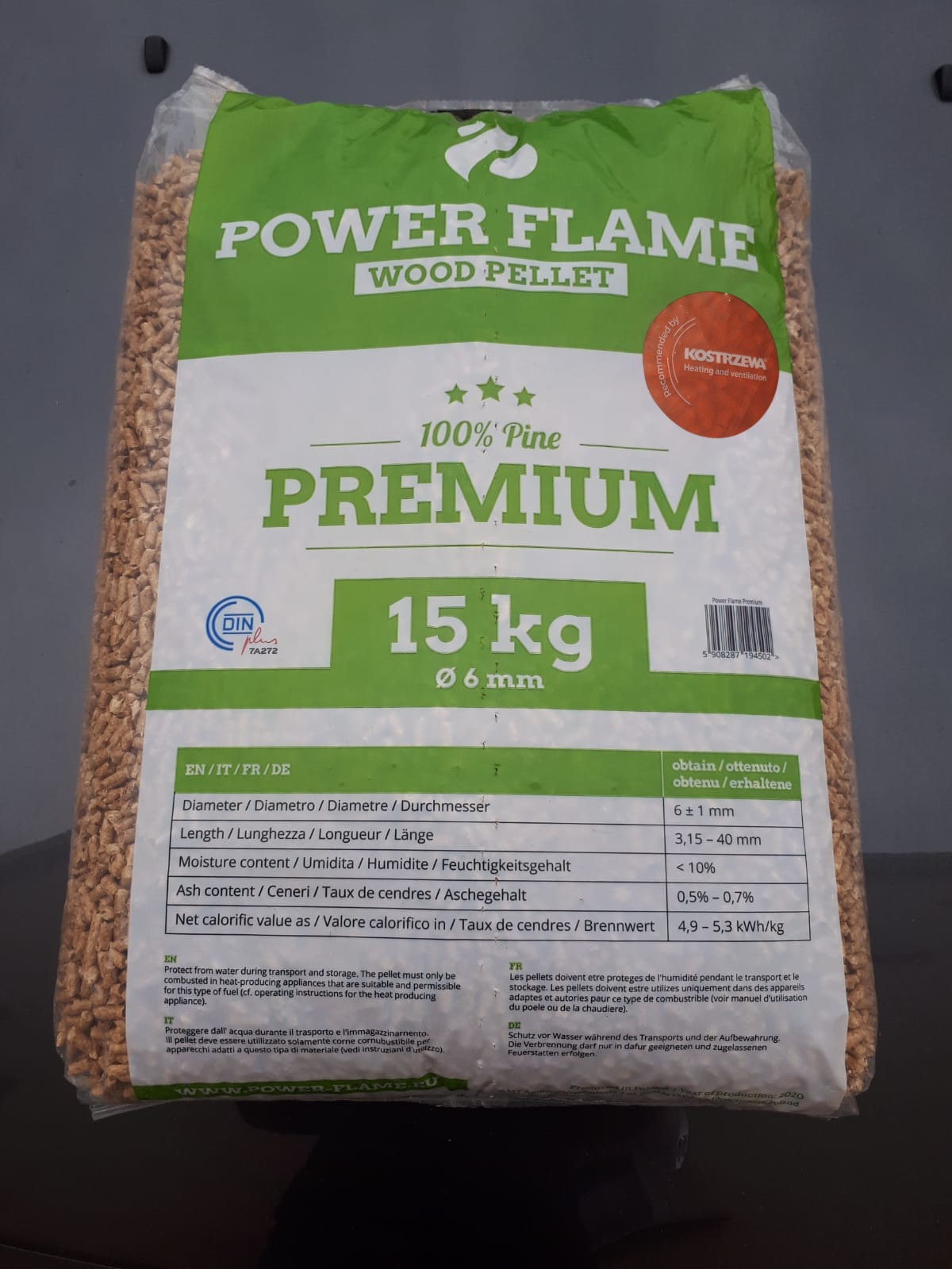 Worek z pelletem drzewnym Power Flame, wykonany w 100% z sosny, o wadze 15 kg i średnicy 6 mm, z informacjami o parametrach w różnych językach i certyfikatem DIN plus.