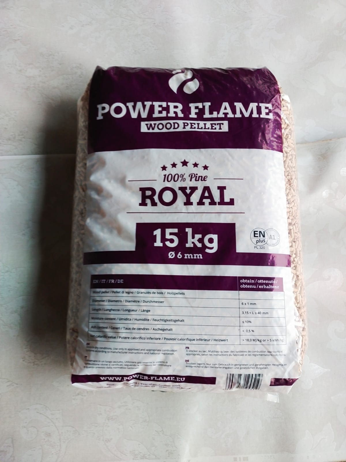 Worek 15kg z jasnymi peletami drzewnymi marki Power Flame Royal, wykonany w 100% z sosny, z widocznymi informacjami o parametrach technicznych w kilku językach.