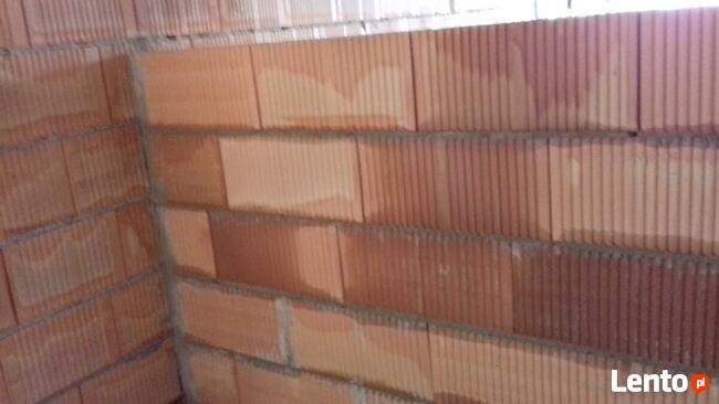 Wewnętrzny narożnik ściany z bloków ceramicznych, widoczne spoiny zaprawy, lekko wilgotna powierzchnia bloków.