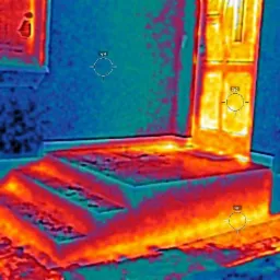 Termowizyjne zdjęcie schodów wejściowych do budynku, ukazujące straty ciepła w kolorach od niebieskiego (chłodne) do żółtego i czerwonego (ciepłe), z zaznaczonymi punktami pomiarowymi Sp1, Sp2, Sp3...