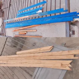 Dwie grupy drewnianych elementów: górna z pomalowanymi na niebiesko listwami i naturalnymi fragmentami, dolna z surowymi listwami z wyciętymi zakończeniami, leżące na betonowym podłożu obok...